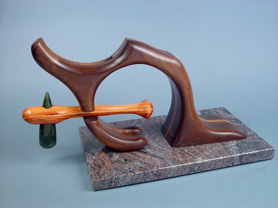 "Manaya" stand with petaloid celt. Celt is held in position with tension in hand-carved walnut and oak base.