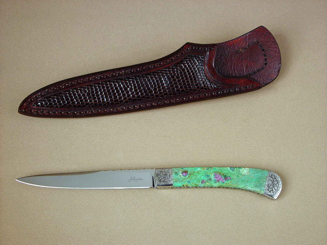 "Shaula" obverse side view in ATS-34 high molybenum stainless steel blade, hand-engraved 304 stainless steel bolsters, Ruby in Fuchsite gemstone handle, lizard skin inlaid in hand-carved leather shoulder