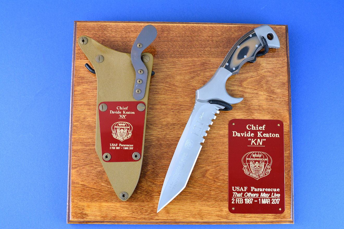 "Uvhash" Custom Commemorative Pararescue Knife, obverse side view, in 440C high chromium stainless steel blade, 304 stainless steel bolsters, coyote/black G10 handle, hybrid tension lock kydex, anodized aluminum sheath, plaque in ash, engraved maroon lacquered brass