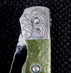 "Gemini" linerlock folding knife engraved bolster detail, obverse side