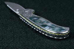 "Izar" linerlock folding knife, handle butt view. Inlays of hard, tough, polished agate are domed up above the polished stainless steel liners and handle sides