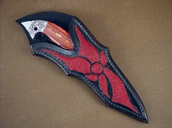 "Mercurius Magnum" sheathed view. Sheath is designed around knife to compliment it, artistically using curves and shapes to frame the handle and point. 