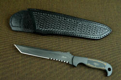 "PJ-CT" obverse side view, front side of black basketweave sheath. This is a compact, narrow, aggressive blade