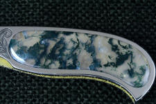 Translucent to transparent, Indian Green Moss Agate gemstone is inlaid in this stainless steel folding knife frame/liner