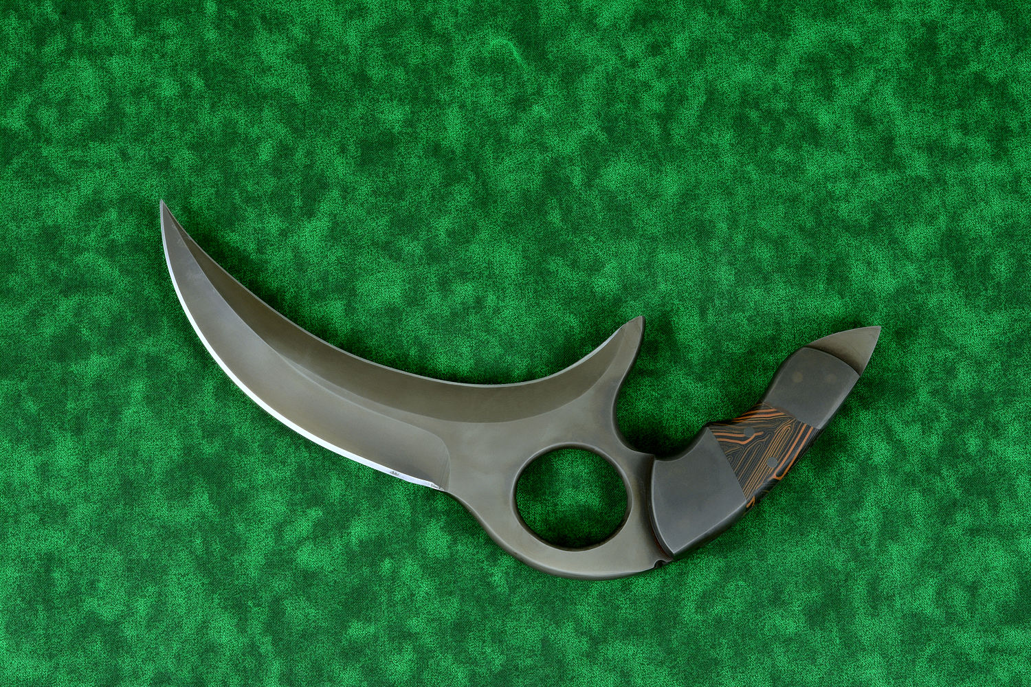 "Drepan" tactical karambit knife, obverse side view in T4 cryogenically treated 440C high chromium martensitic stainless steel blade, 304 stainles steel bolsters, orange/black G10 fiberglass epoxy composite laminate, sheath in leather shoulder, hand-tooled, nylon stitching, stainless steel reinforcement