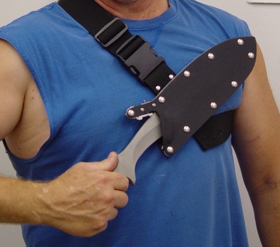 Unlocking and removing the tactical combat knfe from the locking sheath in the sternum harness