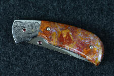 "Bellatrix" custom folding knife in T3 deep cryogenically treated ATS-34 high molybdenum martensitic stainless steel blade, hand-engraved 304 stainless steel bolsters, differerentially anodized 6AL4V titanium liners, Roostertail Agate gemstone handle, 304 stainless steel fasteners with garnet faceted gemstones