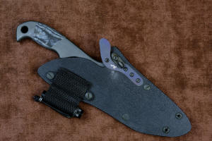"Contego" Counterterrorism Tactical Knife, sheathed view with LIMA mounted upper location, outward orientation, in T3 cryogenically treated CPM154CM  powder metal technology high molybdenum martensitic stainless steel blade, 304 stainless steel bolsters, Black/Gray G10 fiberglass/epoxy composite handle, hybrid tension tab-locking sheath in kydex, anodized aluminum, stainless steel, titanium