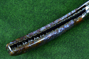 Macro enlargement of "Starling" fine handmade custom folding knife, lock view,  liner and blade filework detail. Note differentially anodized blue and gold titanium liners and full fine filework throughout Macro enlargement of "Starling" fine handmade custom folding knife, lock view,  liner and blade filework detail. Note differentially anodized blue and gold titanium liners and full fine filework throughout