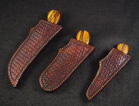 The Trophy Game Set knives sheathed in traditional basketweaved leather shoulder