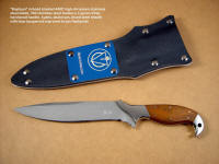 "Kapteyn" professional tactical combat knife, obverse side view; 440C high chromium stainless steel blade, 304 stainless steel bolsters, Lignum Vitae hardwood handle, kydex, aluminum, nickel plated steel sheath with blue lacquered aluminum flashplate