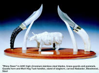 "Rhino Dawn" compimentary knife pair in 440C stainless steel blades, brass guards and pommels, gazelle horn and wart hog tusk handles, carved alabaster, staghorn, bloodwood display stand